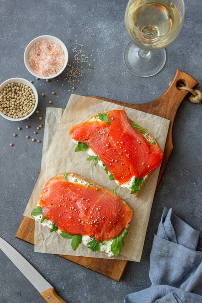Open sandwiches with salmon, arugula and white cheese. Healthy eating - Foto, afbeelding