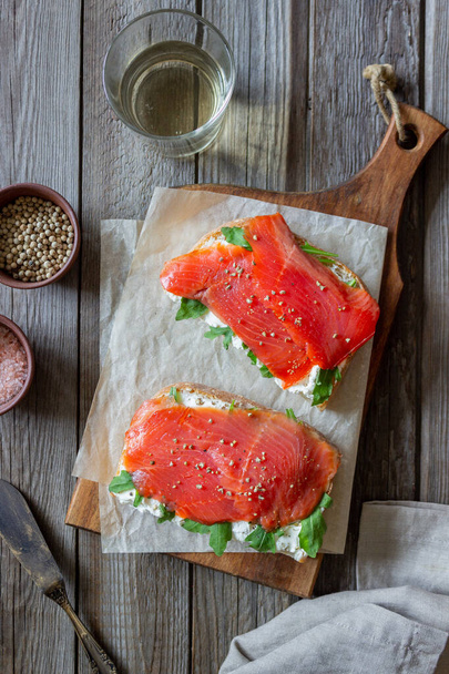 Open sandwiches with salmon, arugula and white cheese. Healthy eating - Foto, Bild