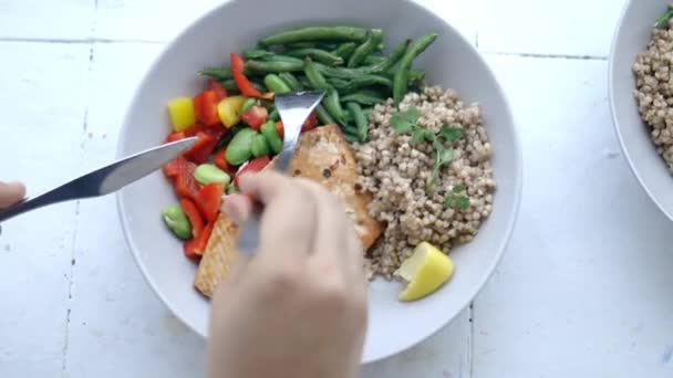 Fork picking green beans from buckwheat and salmon dish - Footage, Video
