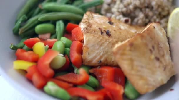 Fork picking salmon from buckwheat and green beans dish - Footage, Video