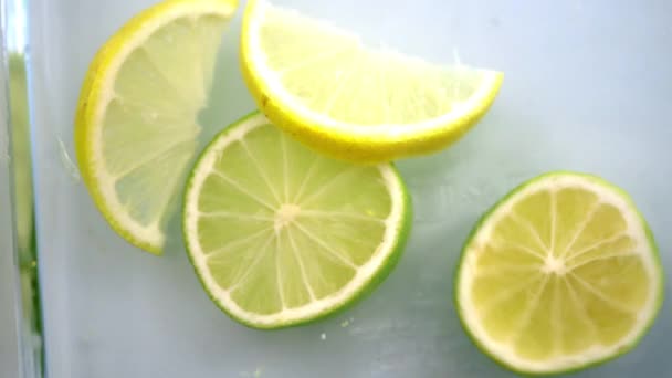 Samičí ruka dávající citróny do vody ve skleněné nádobě - Záběry, video