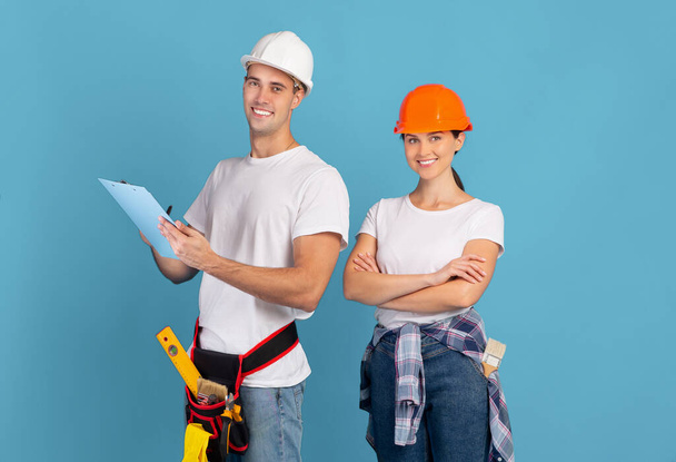Repairment Budget Planning. Portrait Of Man And Woman Repair Masters In Helmets - Photo, Image