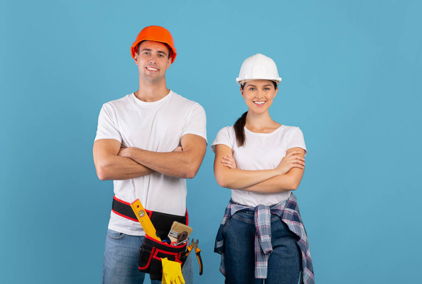 Couple de jeunes confiants dans des chapeaux durs prêts pour la réparation et la rénovation de la maison - Photo, image