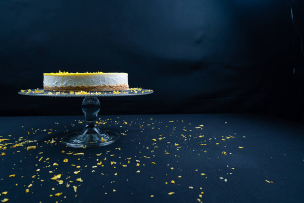 Sliced lemon cheesecake on glass plate at black background. (Copyspace) - Valokuva, kuva