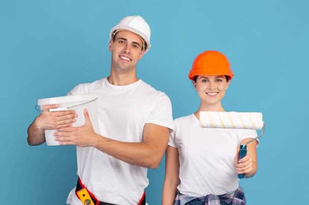 Paar von Reparaturmeistern posiert mit Farbeimer und Pinsel - Foto, Bild
