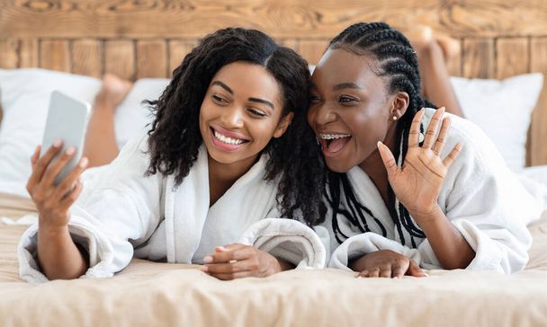 Neşeli Afrikalı Amerikalı kadınlar otelden kız arkadaşlarını arıyor. - Fotoğraf, Görsel