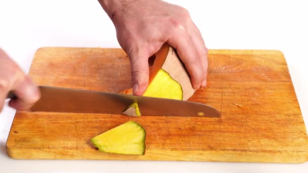 viipaloitu kurpitsa kuorittuna leikkuulaudalle veitsellä - Materiaali, video