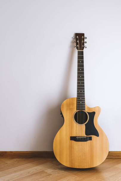 Guitarra acústica contra a parede
 - Foto, Imagem