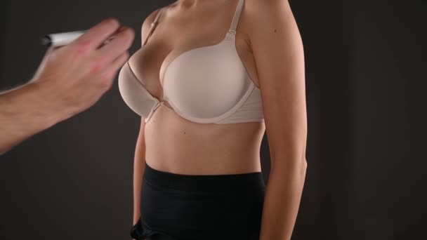 Lékař kreslení značky na ženských prsou před operací kosmetické chirurgie - Záběry, video