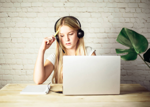 Angol online lecke, tizenéves lány visel fejhallgató tanul online - Fotó, kép