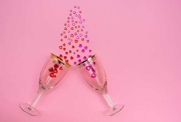 Valentines Day holiday. Wine glasses on a pink background. Crystals in glasses. - Фото, изображение