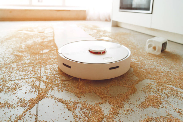 Thuis stofzuigen robot in actie op echte woonkamer houten vloer. Selectieve focus op robot. - Foto, afbeelding