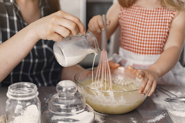 Family in a kitchen cook the dough for cookies - Фото, изображение
