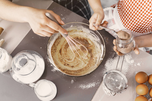 Family in a kitchen cook the dough for cookies - 写真・画像