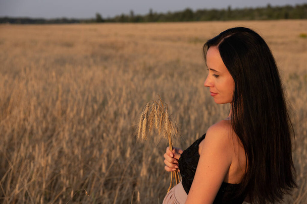 Beautiful young woman enjoying nature in a wheat field, sunset. Travel concept. ecological tourism. Soft focus. - Foto, immagini