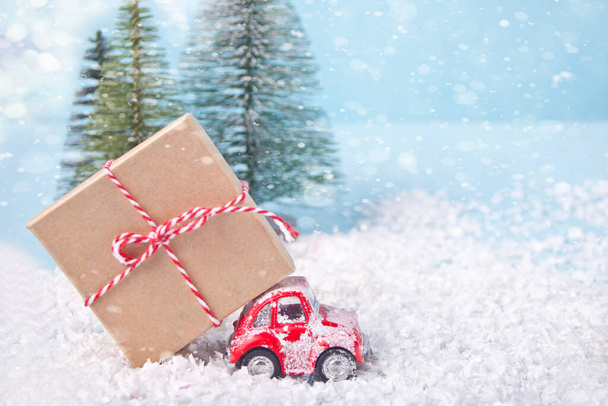 Christmas card for Christmas and New Year. Holiday composition with pine trees, toy red car and gift box - Photo, Image