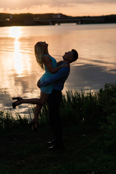 Силуэт, любящая пара на озере во время заката - Фото, изображение