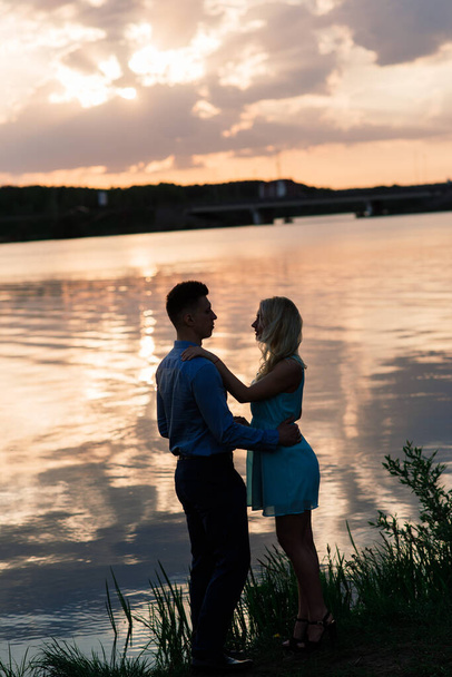 Silouette, loving couple on the lake during sunset - Photo, Image