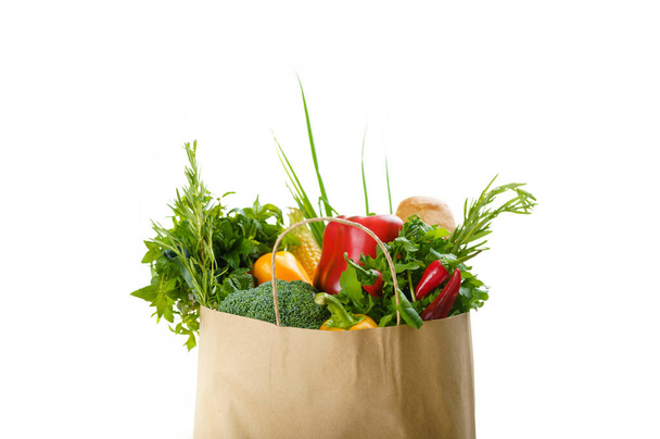 Surowe warzywa i owoce w papierowej torbie, izolowane na białym tle. Organiczne jedzenie wegetariańskie, produkty spożywcze, koncepcja zdrowego stylu życia - Zdjęcie, obraz