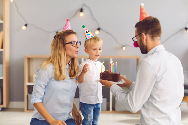 Happy mother and father congratulating little son with birthday with cake - Photo, image