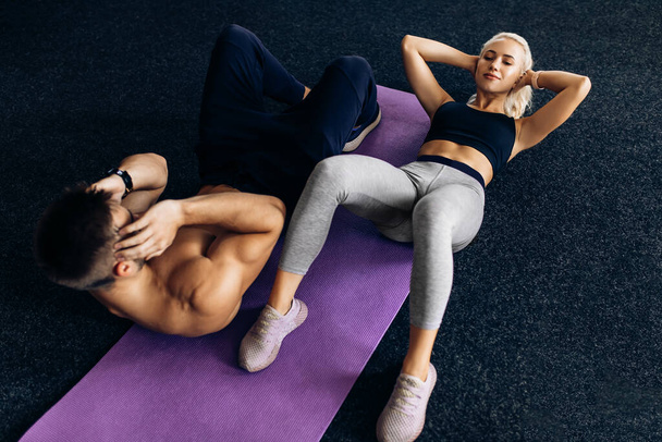 Sportive couple, woman and man train together, do exercises on the press in the gym, sport, fitness - Fotoğraf, Görsel