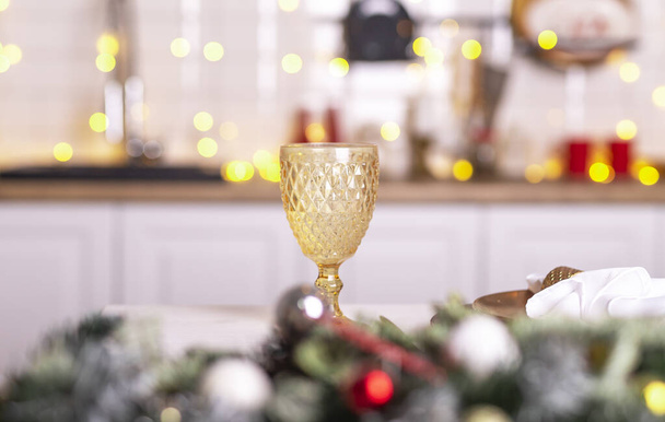 Christmas wineglass on dining table of decorated kitchen. - Foto, immagini