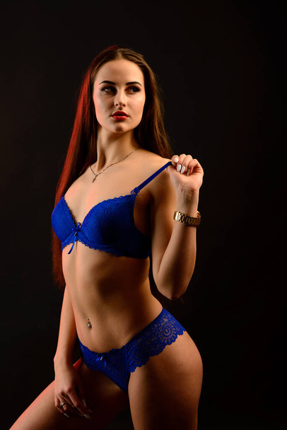 Krásná sexy žena v modrém spodním prádle na tmavém pozadí, perfektní ženské tělo, studio shot - Fotografie, Obrázek
