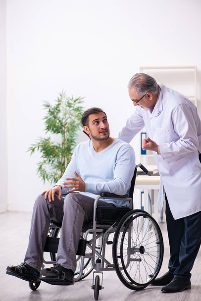 Mladý muž na vozíku a starý lékař traumatolog - Fotografie, Obrázek