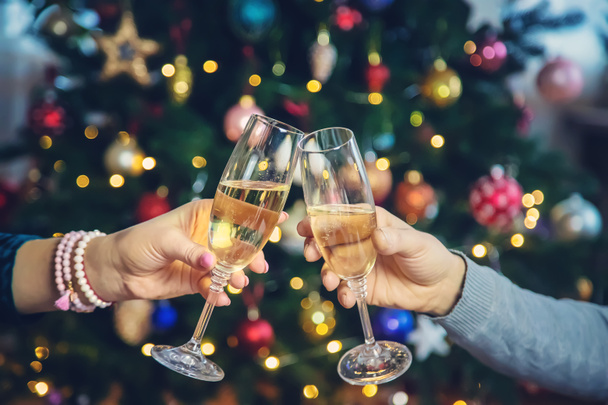 Champagne in hand against the background of the Christmas tree. People. Selective focus. Holiday. - Foto, imagen