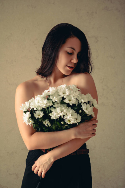 young sexy woman cover brest with bouquet of white flowers gentle beauty - Photo, Image