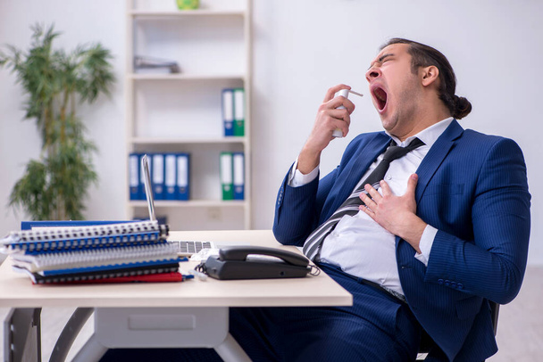 Sick male employee suffering at workplace - Foto, Imagen
