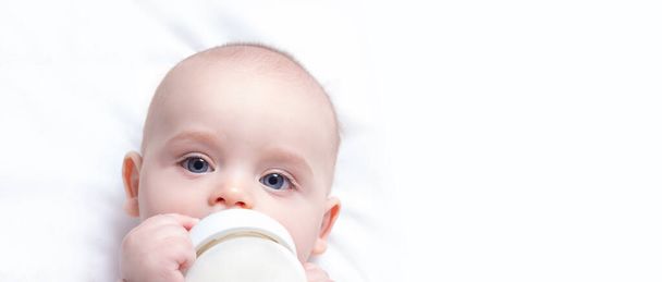 Artificial feeding concept. Baby with milk bottle. - Foto, afbeelding