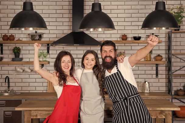 Vegetarian concept. everyday winners. Mother and father cooking with daughter. happy family day. friendly family in kitchen. healthy food at home. kid cook dinner with parents. do everything together - Фото, изображение