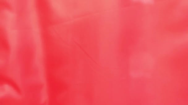 Scarlet glanzende textiel vlag trilt op een wind in close-up en slow motion - Video