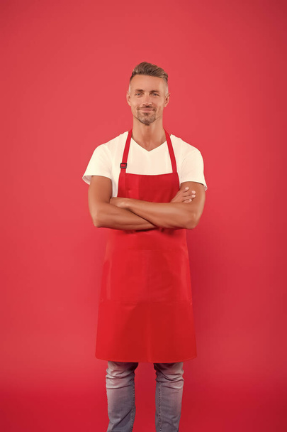 hospitable and confident husband. man in apron at kitchen. handsome janitor wear uniform for cleaning. friendly smiling bartender. Professional cleaning. household and people concept - Foto, Imagem