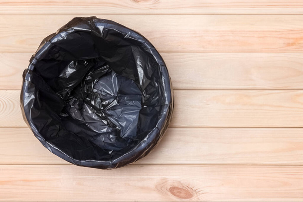 Empty Bin on Wooden Background. Trash Can Top View. Garbage Basket. Rubbish Black Bag in a Trash Can. Empty Rubbish Bin. Waste Can with Plastic Package. Empty Garbage Bin. Bin on Wooden Floor. Trash - Fotografie, Obrázek
