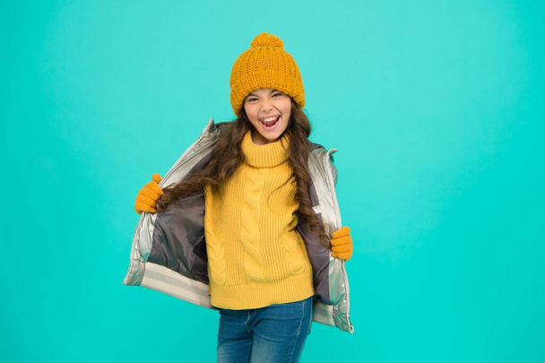 smiling teenage girl in padded or puffer jacket ready to spent winter holiday and vacation in comfort and warmth, carefree and funny - Photo, image