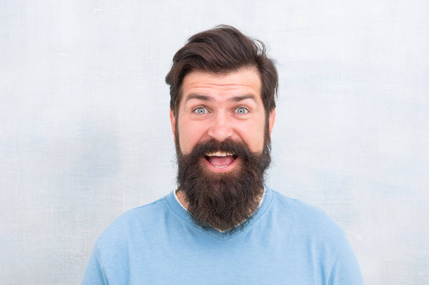 Hipster appearance. Beard fashion and barber concept. Perceptions of male beauty around the world. Man bearded hipster stylish beard grey background. Stylish beard and mustache care. Happy face - Foto, Imagem