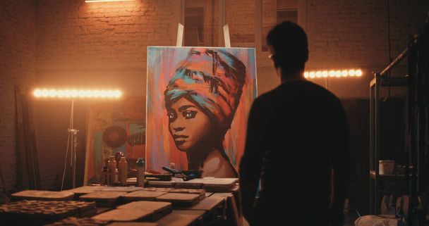 Unbekannter Künstler bewundert Porträt schwarzer Frau - Foto, Bild