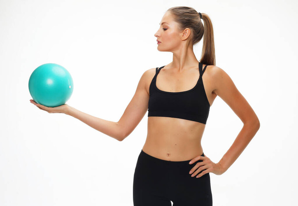 Young fit adult woman doing yoga exercise workout with gymnastics ball. - Foto, Imagem