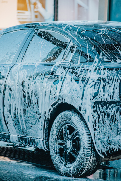 Das Auto waschen. Waschen eines schwarzen Autos in einer Waschanlage. Sauberes Auto - Foto, Bild