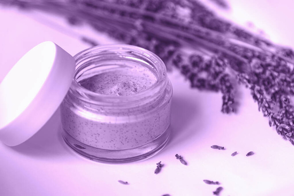 Natürliche handgemachte kosmetische Cremedose und getrocknete Lavendelblüten, in violett getönt. Bio-Kosmetik, Aromatherapie-Konzept - Foto, Bild
