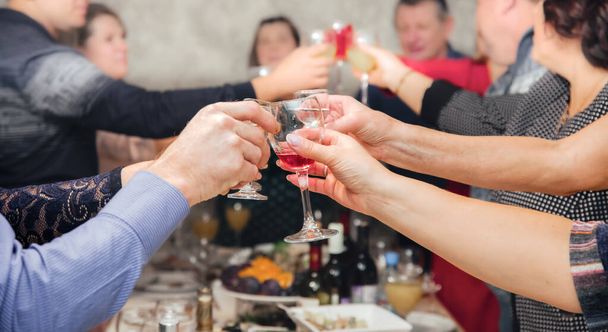 Handen vasthouden van glazen wijn tijdens het vieren - Foto, afbeelding