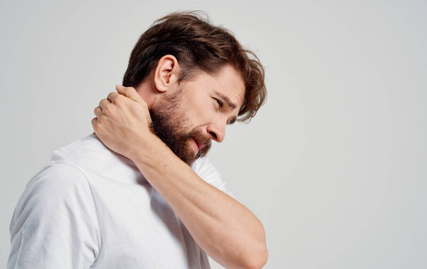 jeune homme toucher le cou avec les mains douleur colonne vertébrale vue latérale modèle portrait - Photo, image