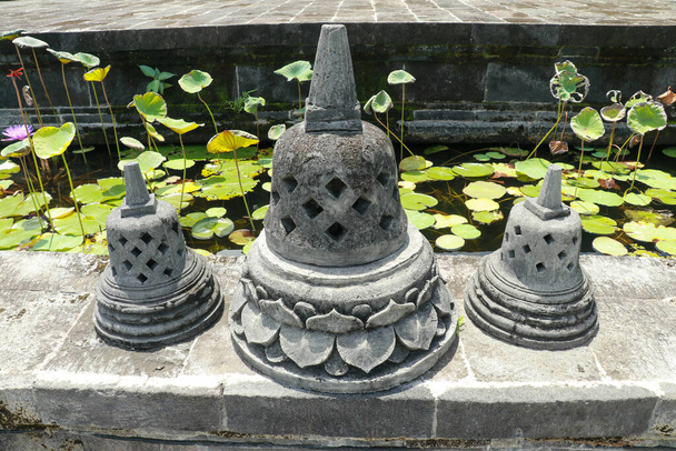 Stupas arreglo en las escaleras en Borobudur templo budista. Campanas de piedra negra en el templo de Brahmavihara arama, Bali, Indonesia. - Foto, imagen