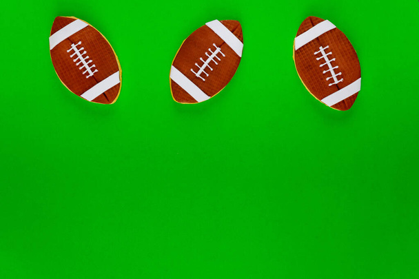 Rugby balls cookie on green background. American football background. - Photo, Image