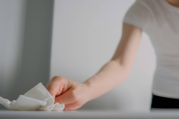 Mujer limpiando mesa blanca con toallita húmeda - concepto de desinfección - Foto, Imagen