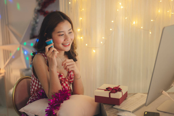 美人若いアジアの女性黒髪お祝いクリスマスオンラインパーティーで紙の撮影. - 写真・画像