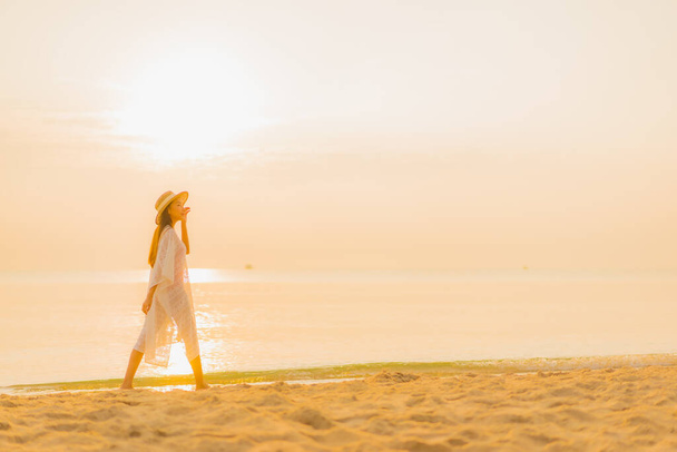 Retrato bonito jovem asiático mulher relaxar sorriso lazer ao redor mar ao ar livre praia oceano no por do sol tempo para férias - Foto, Imagem