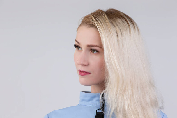 Girl dyed blonde twenty-five years of age on a gray background. - Fotografie, Obrázek